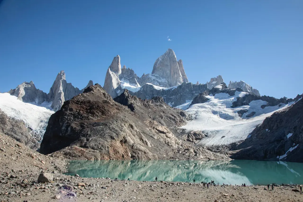 Majestätische Berge spiegeln sich in einem türkisfarbenen See. Die Szene vermittelt das Gefühl, dass dies die **Patagonien beste Reisezeit** ist, um diese atemberaubende Landschaft zu erleben.