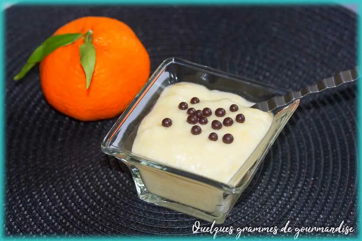Mousse clémentine mascarpone légère et aérienne, décorée de perles de chocolat. Une clémentine fraîche à côté.