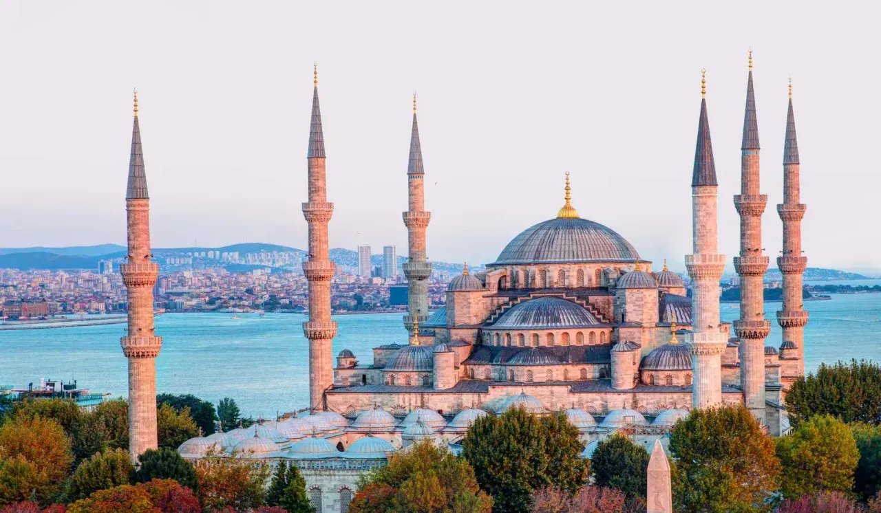 Impresionante mezquita con seis minaretes y cúpulas, bañada por la luz dorada del atardecer. Un paisaje de **estambul fotos bonitas** que te transporta a otra época.