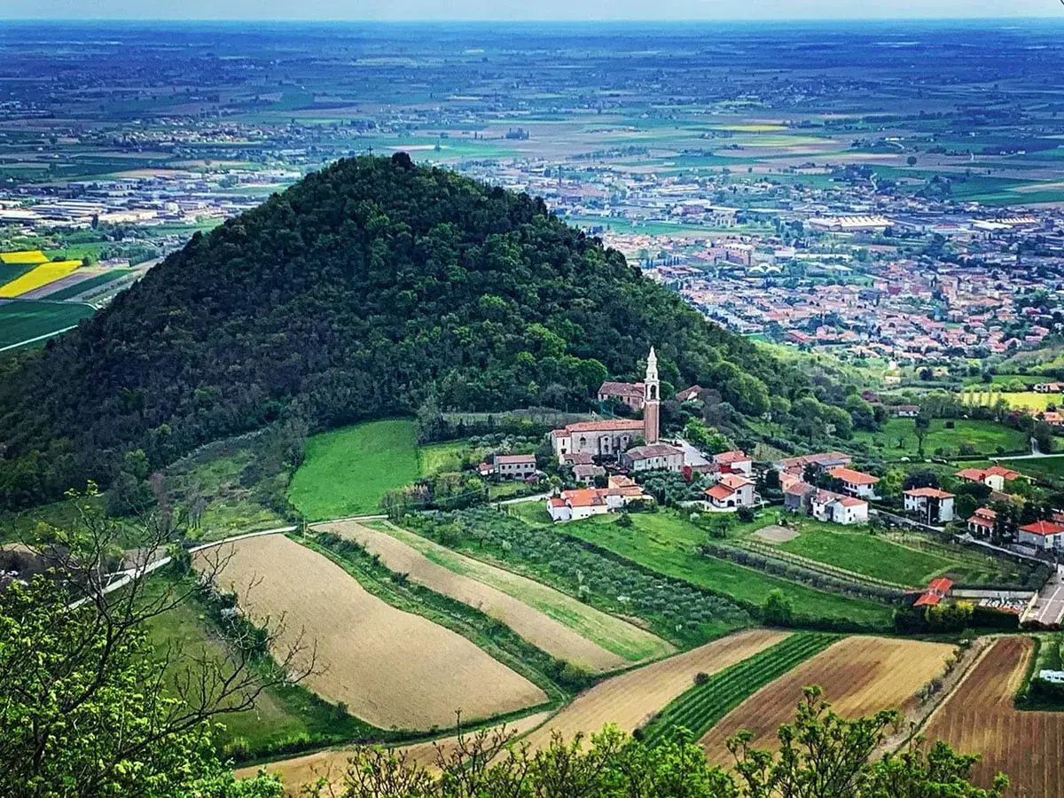 Panoramica dei Colli Euganei con un borgo e campi coltivati. Ideale per scoprire i ristoranti dei Colli Euganei.