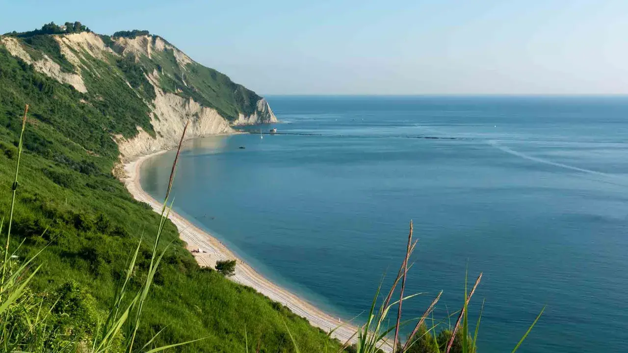Vista panoramica della spiaggia di Mezzavalle, con scogliere verdi e mare azzurro. Le recensioni la descrivono come un paradiso.