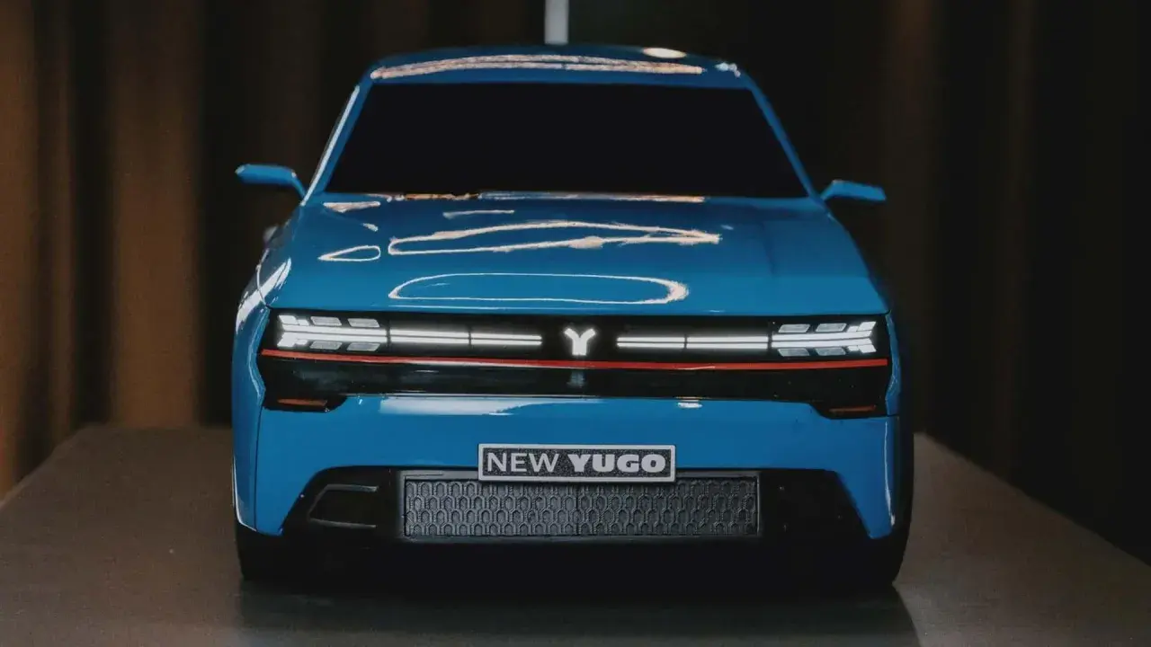 En blå, modern yugo bil med en Y-logotyp och texten "NEW YUGO" på fronten.