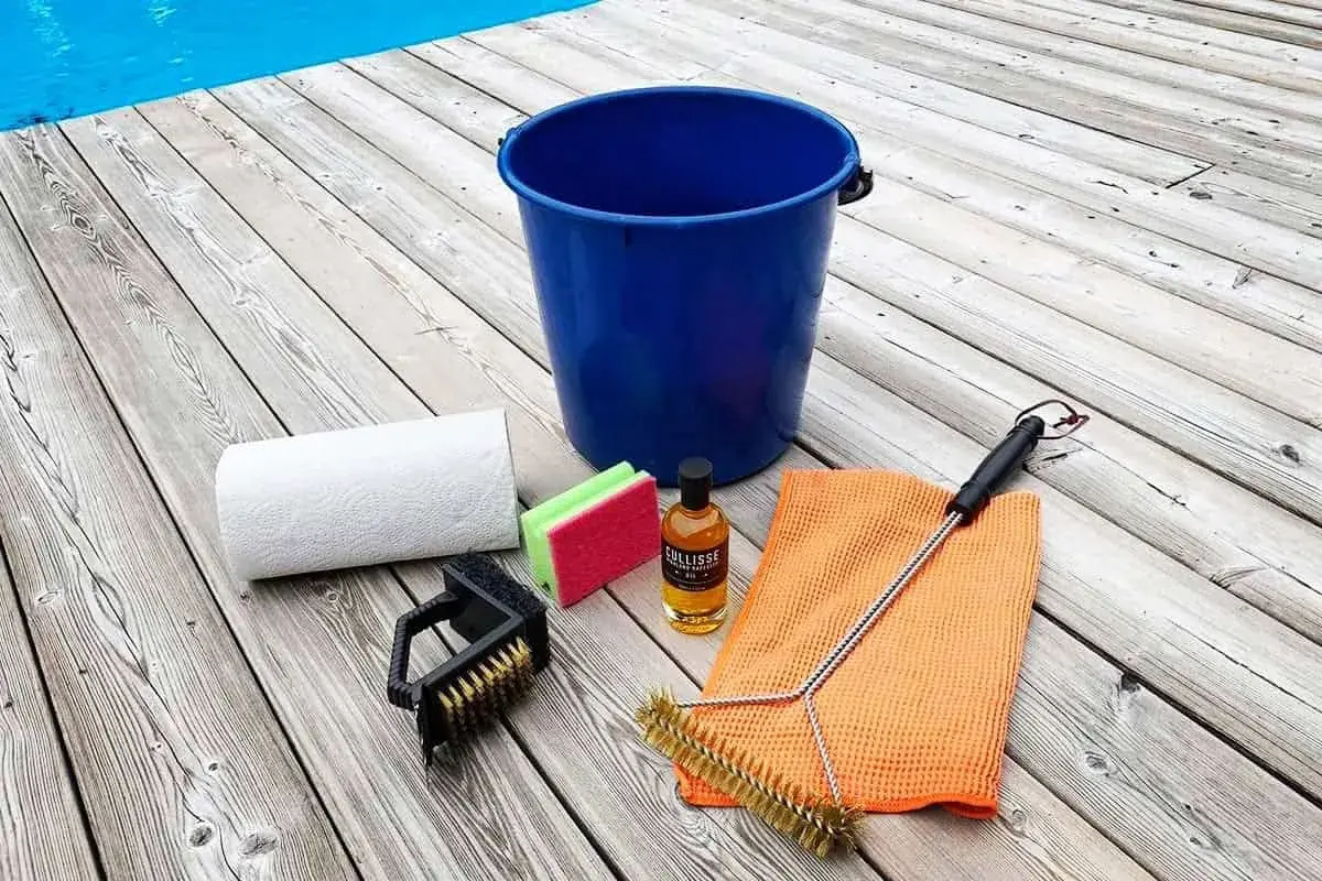 Allt för att rengöra gasolgrill: hink, borstar, svamp, papper och rengöringsolja.