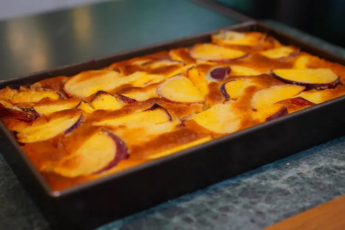 Clafoutis aux pêches dorées, tout juste sorti du four, prêt à être dégusté.