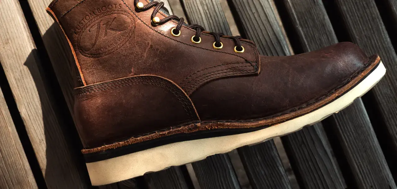 Brown leather boot with white sole. The stitching and laces are visible. This boot might make noise when you walk if the sole is loose.
