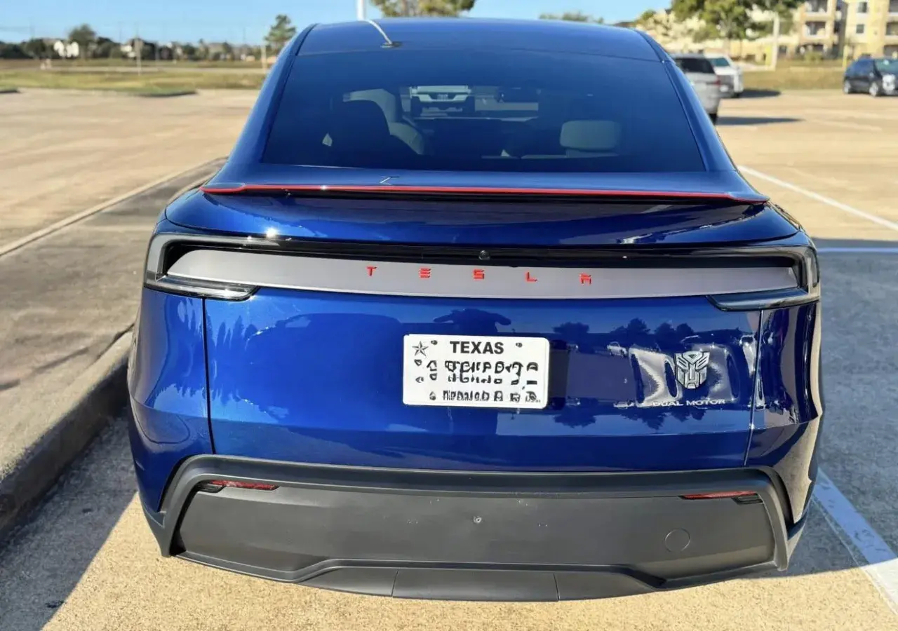 Blå Tesla med registreringsskylt från Texas. En Transformers-logga sitter bredvid "Dual Motor".