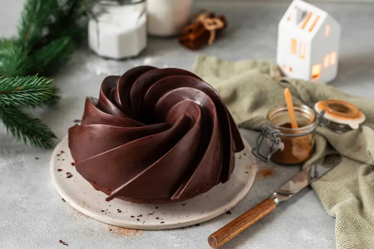 Eine kunstvolle Gugelhupf-Form, überzogen mit glänzender Schokoglasur. Perfekt, um Schokoglasur selber machen zu lernen und diesen Genuss zu kreieren.