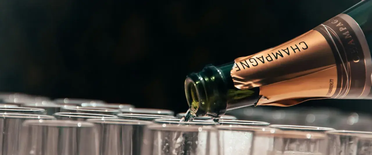 Versando champagne in bicchieri, la temperatura servizio è perfetta per un brindisi.
