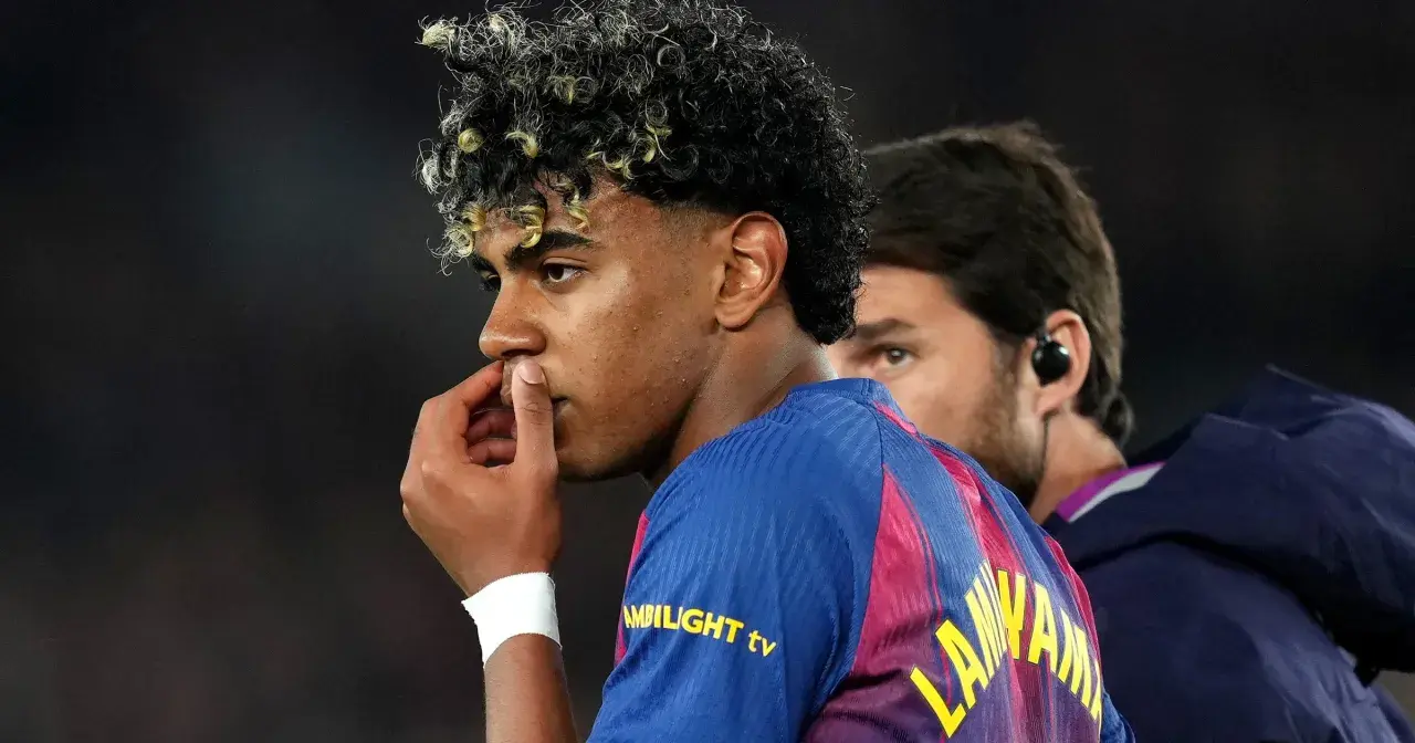 Młody piłkarz Lamine Yamal z FC Barcelony, z charakterystyczną fryzurą, zamyślony, być może po kontuzji.