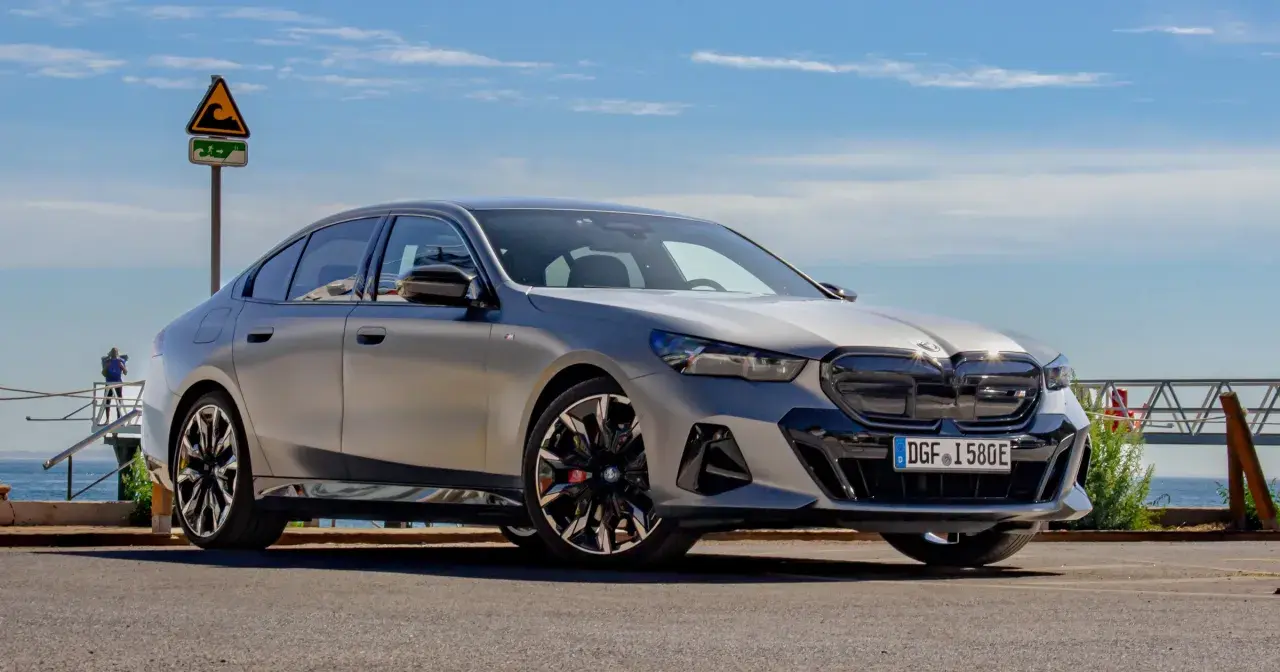 Srebrne BMW 520 z czarnymi akcentami stoi na tle błękitnego nieba i morza.