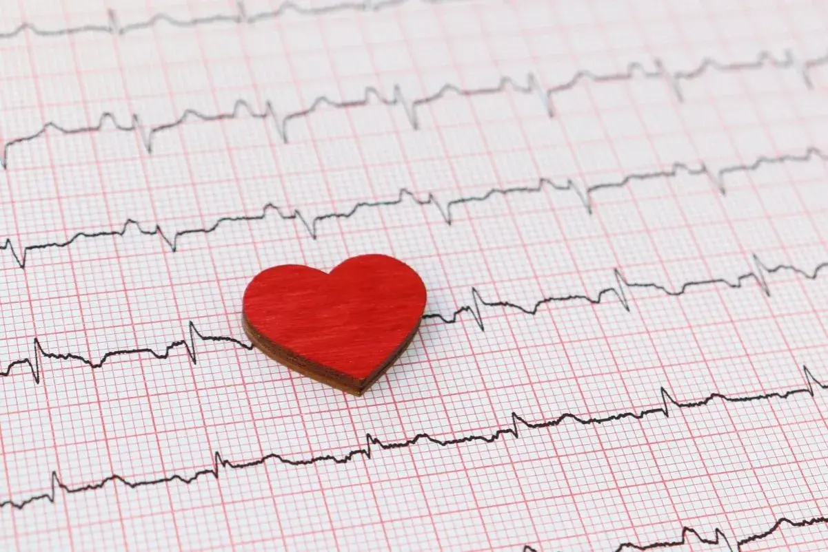 Czerwone serduszko na tle zapisu EKG. Może symbolizować troskę o serce i świadomość objawów wysokiego ciśnienia.