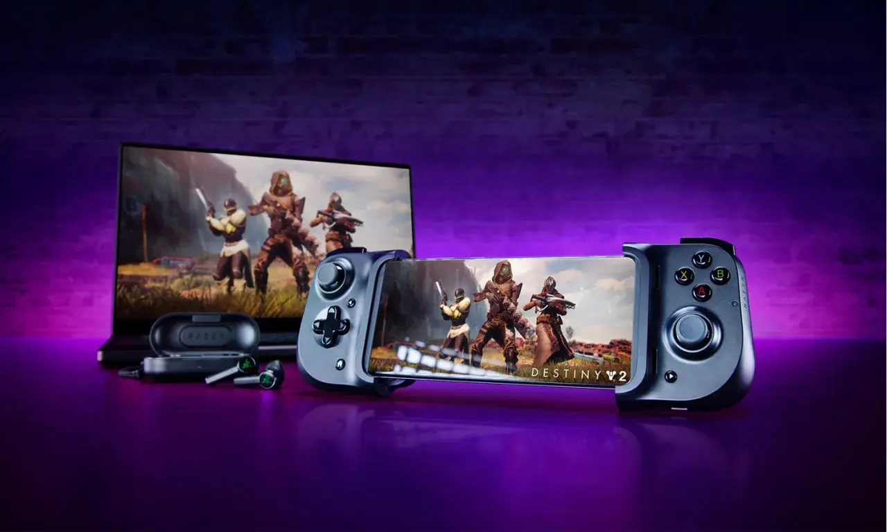 Gry na pada: smartfon z padem Razer Kishi i słuchawki, obok laptop z grą Destiny 2.