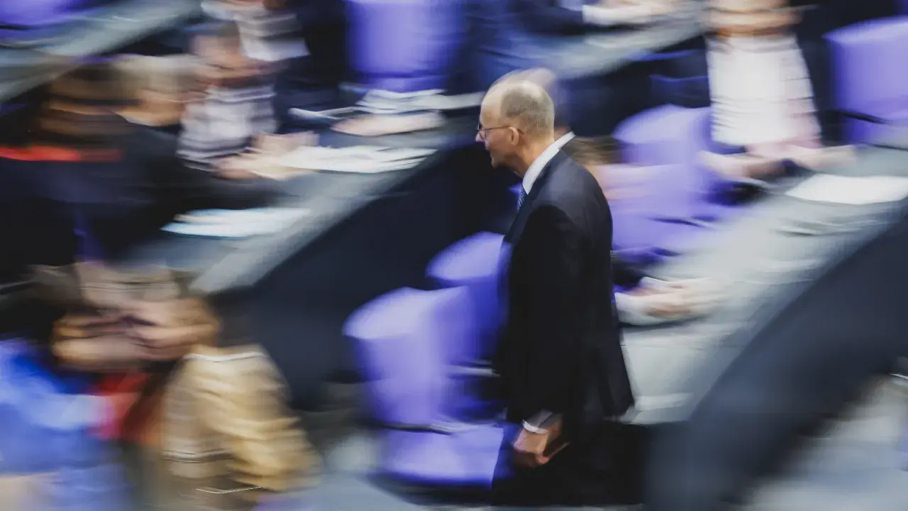 Mann im Anzug geht durch den Bundestag. Wer darf Bundeskanzler werden? Die Frage beschäftigt viele.