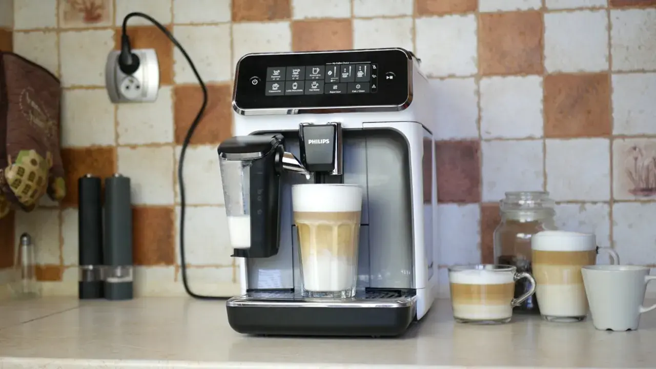 Philips LatteGo 3200 w trakcie czyszczenia obiegu mleka. Na blacie stoi ekspres, obok niego szklanka z kawą latte.