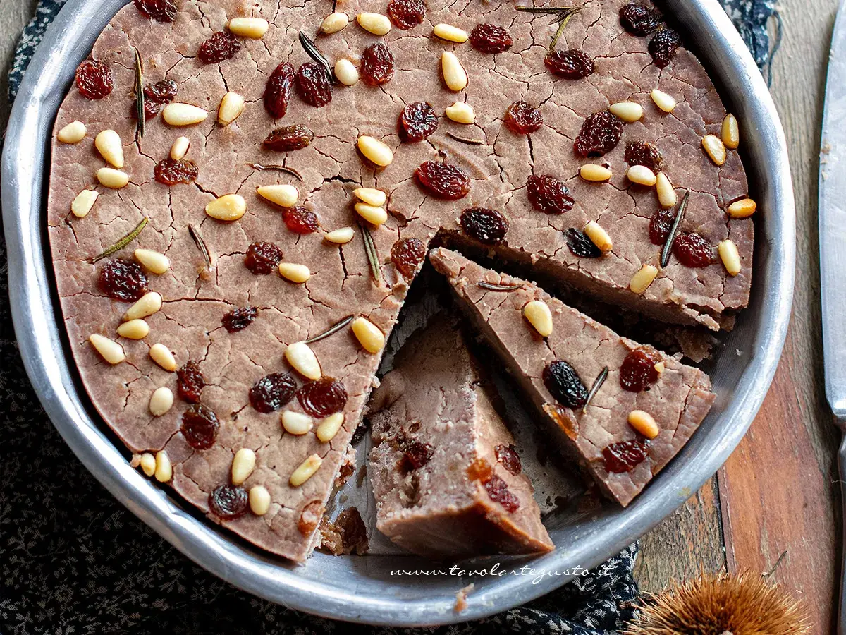 Delizioso castagnaccio con latte, guarnito con pinoli, uvetta e rosmarino. Una ricetta tradizionale per un dolce autunnale.