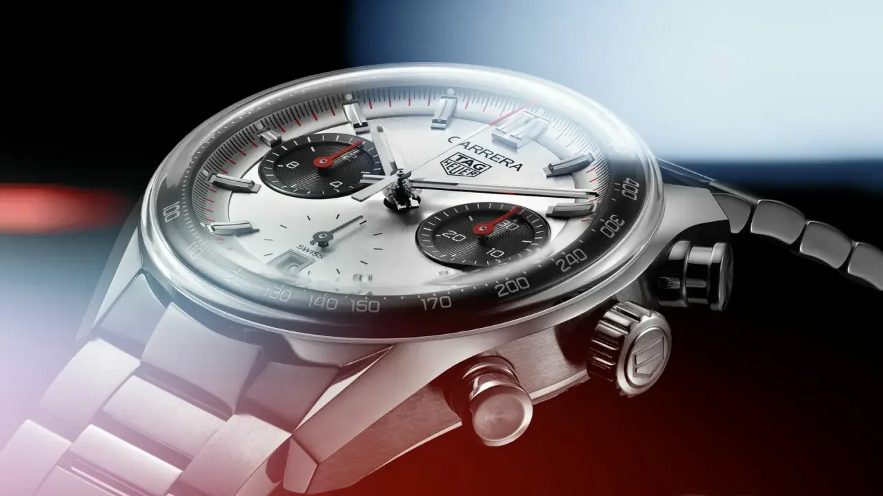 Primer plano de un reloj TAG Heuer Carrera. El cristal mineral se raya levemente, mostrando la esfera plateada y los sub-diales negros.