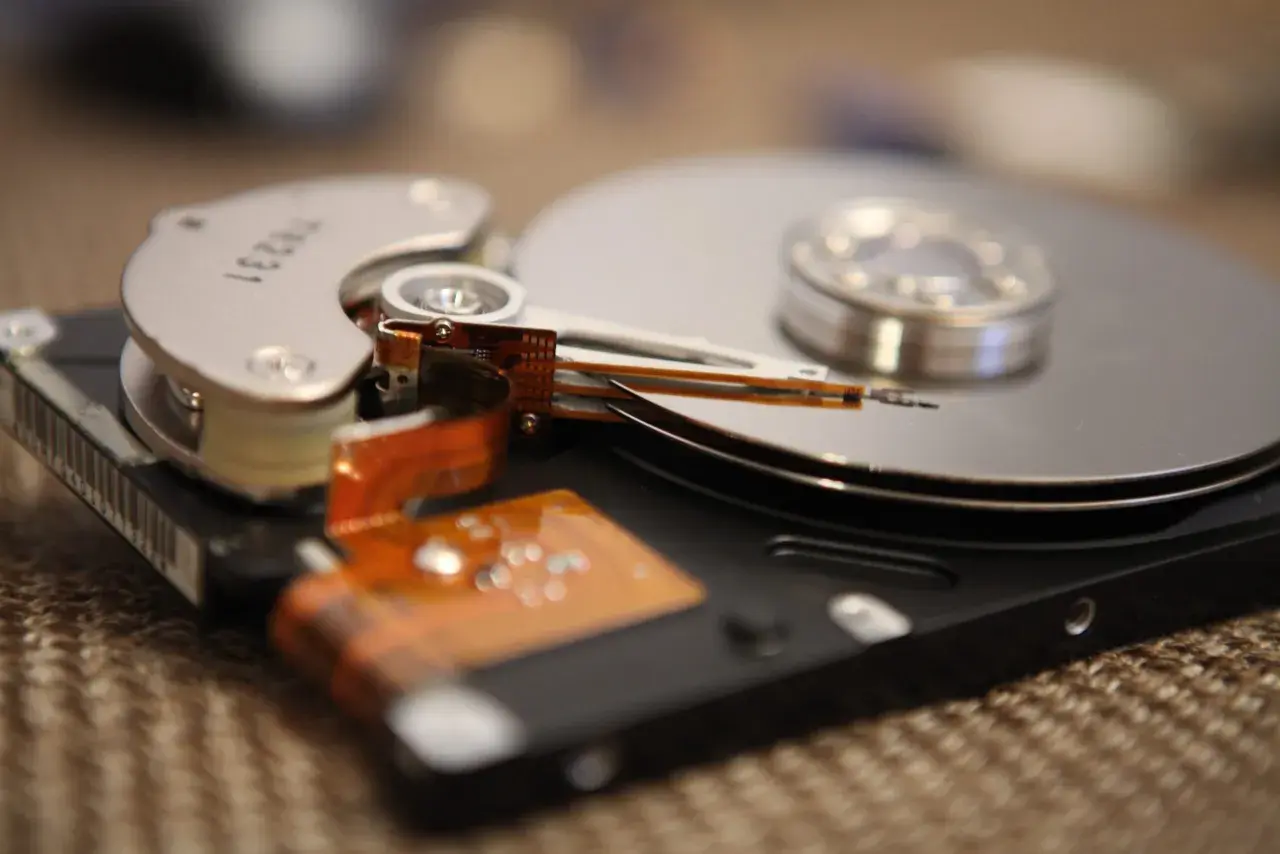 Nahaufnahme einer geöffneten Festplatte, die zeigt, wie die Lese-/Schreibköpfe über die Spindeln gleiten. Dies ist ein Beispiel für die Technologie, die früher für die Datenverwaltung verwendet wurde, bevor SSDs mit TRIM-Funktion aufkamen.