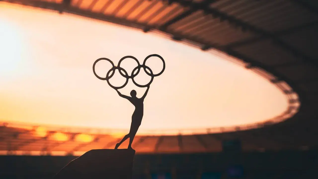 Sylwetka sportowca z pięcioma pierścieniami symbolizuje pierwsze igrzyska olimpijskie.