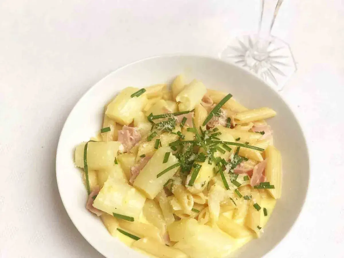 Cremige Spargel Carbonara mit Penne, Schinken und frischem Schnittlauch garniert. Ein Genuss für jeden Gaumen!