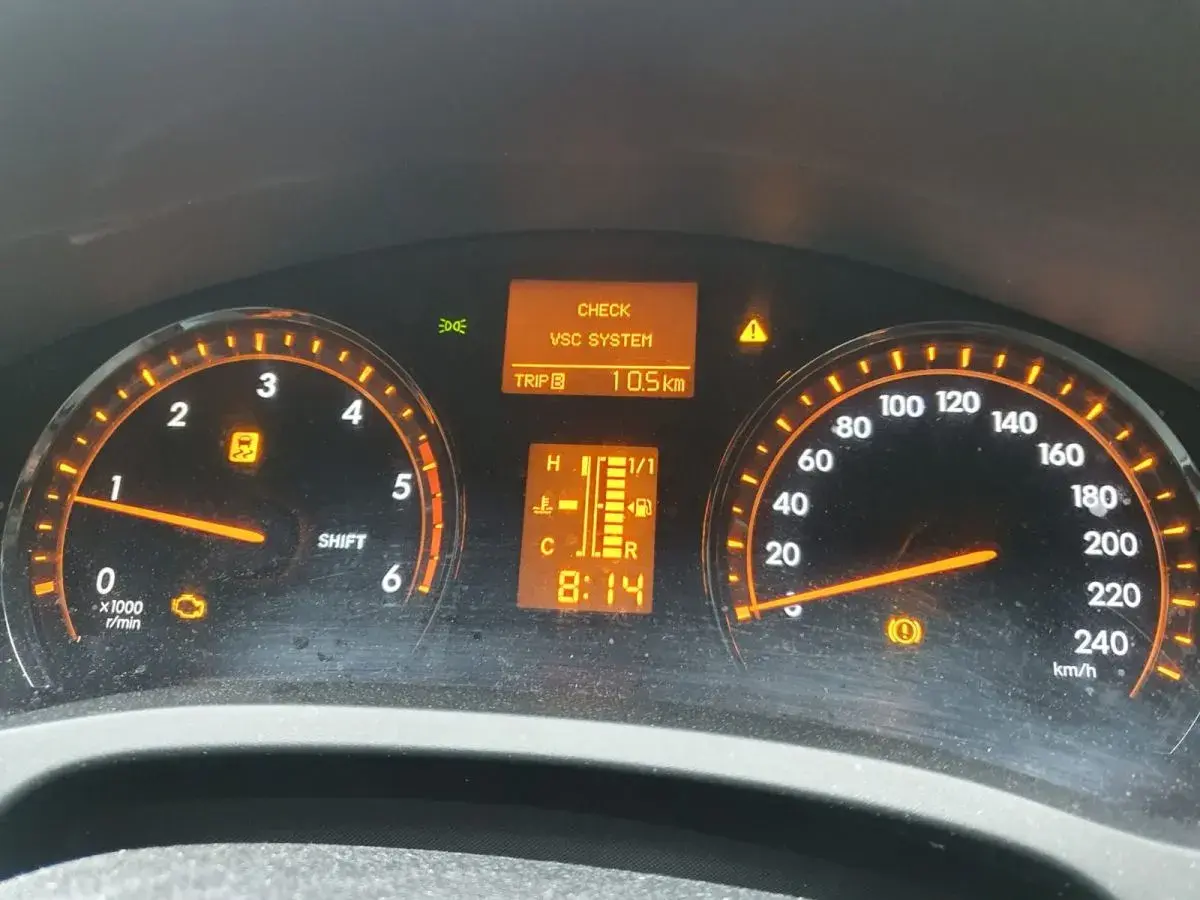 Kontrolki na desce rozdzielczej Toyota T27: CHECK VSC SYSTEM, kontrolka silnika, kontrolka ESP i hamulca. Przebieg 10.5 km.