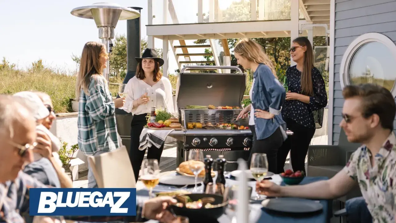 People enjoying a barbecue on a sunny patio with a Bluegaz Z1 grill.