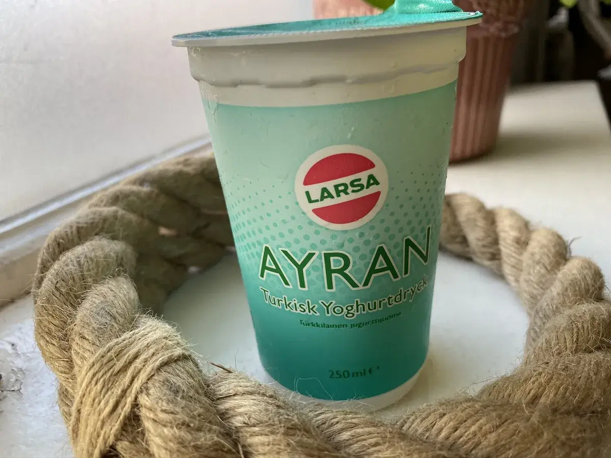 En kopp Larsa Ayran, turkisk yoghurt, står på ett bord. Perfekt för ett snabbt ayran recept.