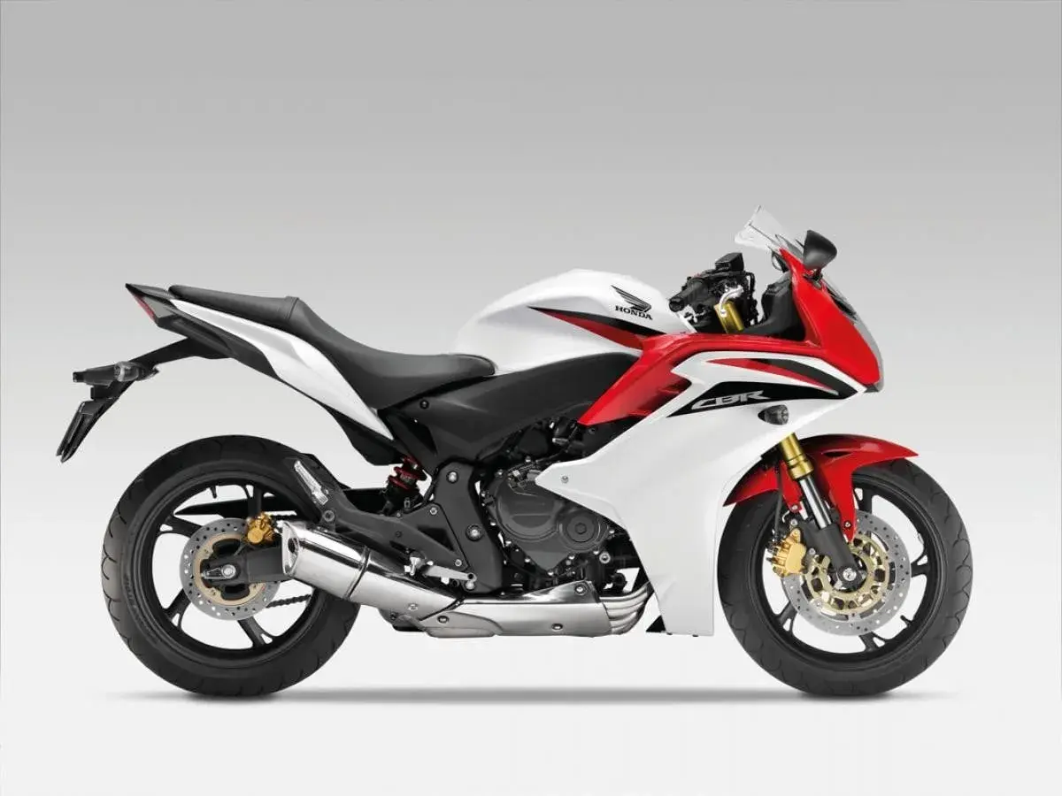 Sportowy motocykl Honda CBR600F w białej i czerwonej kolorystyce, gotowy do dynamicznej jazdy.