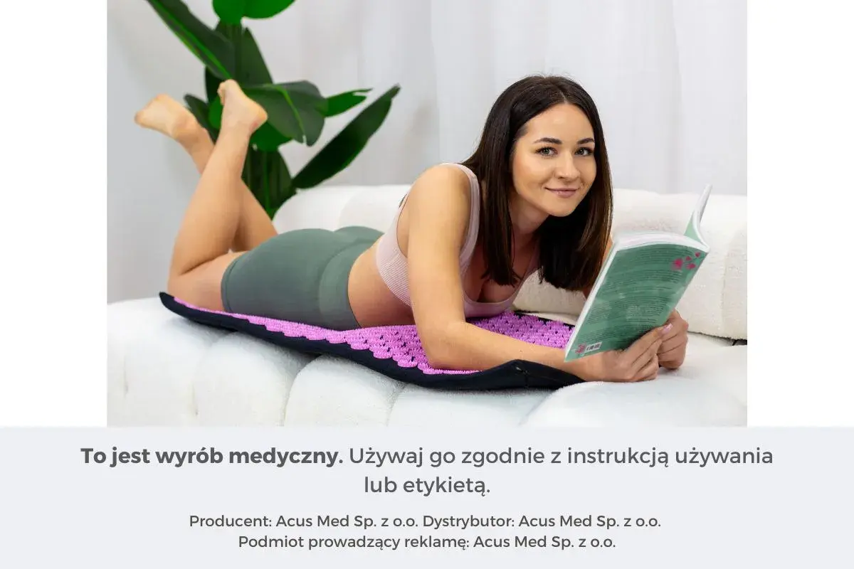 Kobieta czyta książkę, leżąc na fioletowej macie do akupresury na brzuch. Relaks i zdrowie.