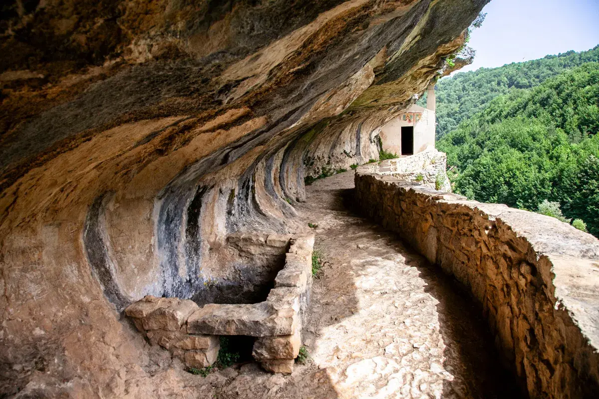 Sentiero roccioso verso l'eremo di San Bartolomeo, incastonato nella roccia con vista su boschi rigogliosi. Come arrivare?