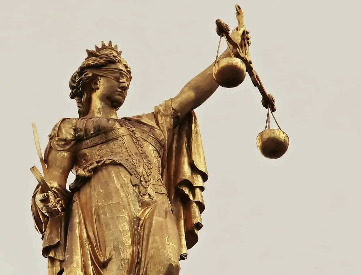 Złota statua Temidy z przepaską na oczach i wagą w dłoni, symbol sprawiedliwości, która może być utrudnianie korzystania z lokalu.