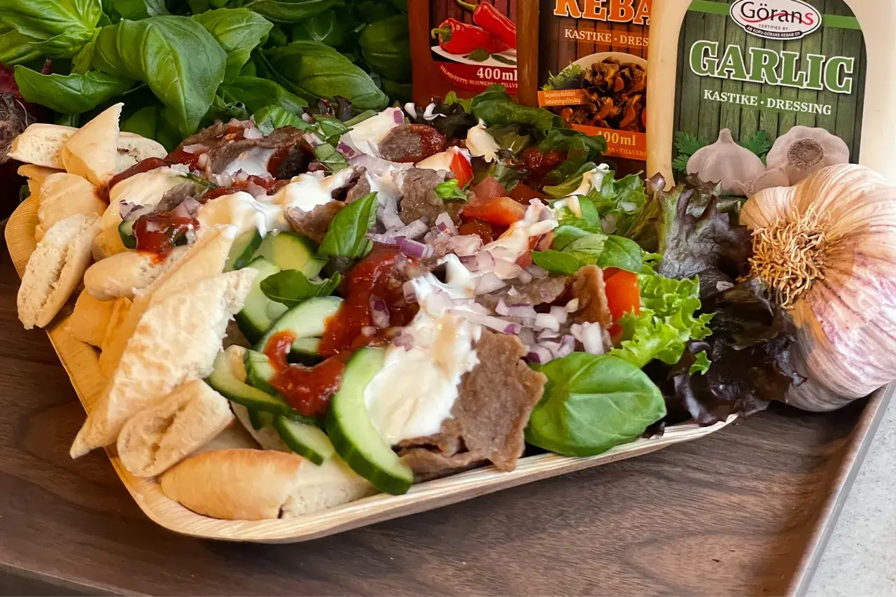 En läcker tallrik med iskender kebab, fylld med kött, grönsaker, bröd och såser. Perfekt för en smakrik måltid.
