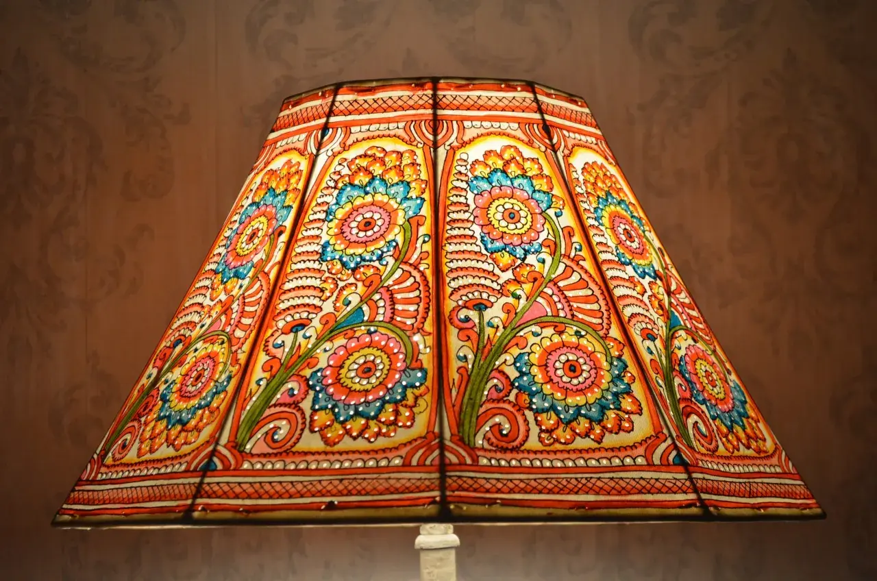 Pantalla lampara de pie con diseño floral vibrante en tonos naranjas, azules y amarillos.