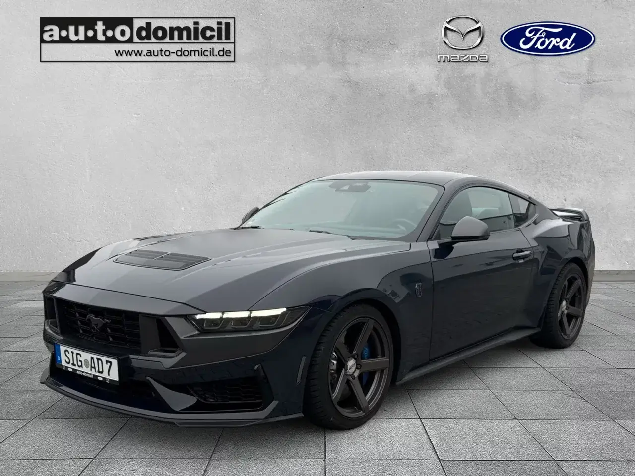 Ciemnogranatowy Ford Mustang z 2023 roku, z czarnymi felgami i sportowym wyglądem. Sprawdź atrakcyjną mustang cena!