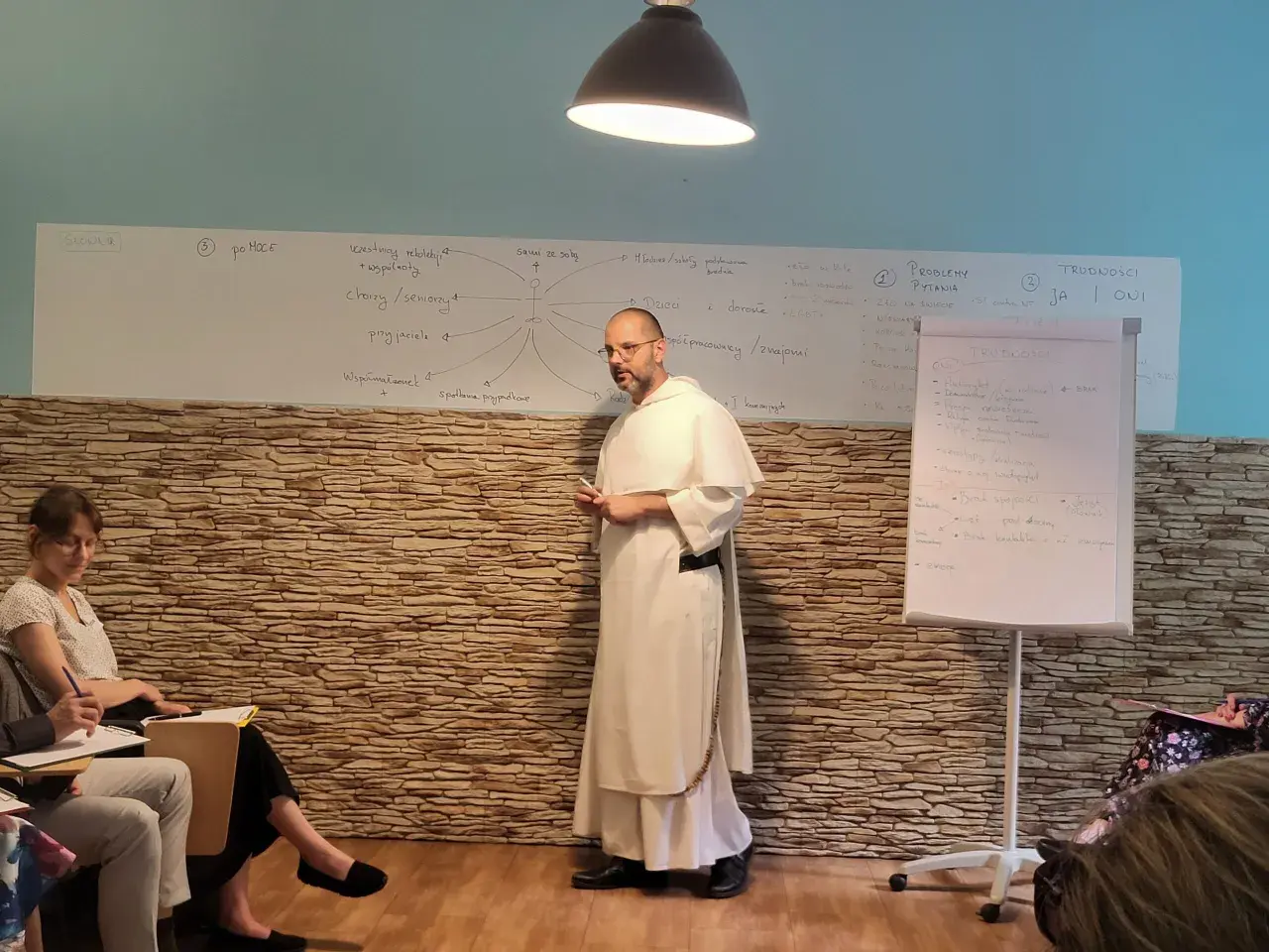 Wykład o tym, jak rozmawiać z niewierzącymi rodzicami o chęci powrotu do kościoła. Na tablicy schemat relacji i trudności.