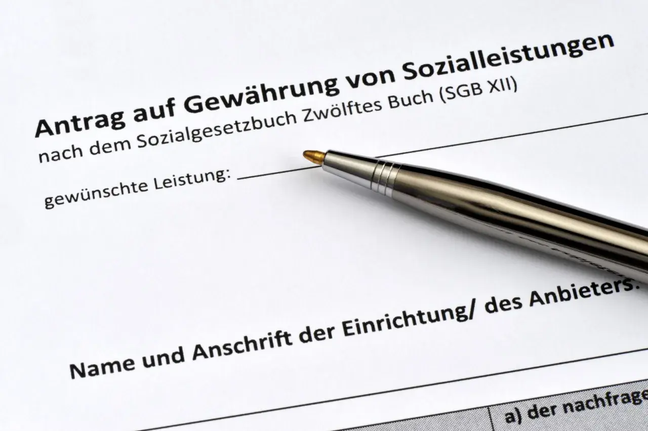 Antrag auf Sozialleistungen mit Stift. Viele Menschen teilen ihre sozialbetrug erfahrungen, wenn sie solche Formulare ausfüllen.