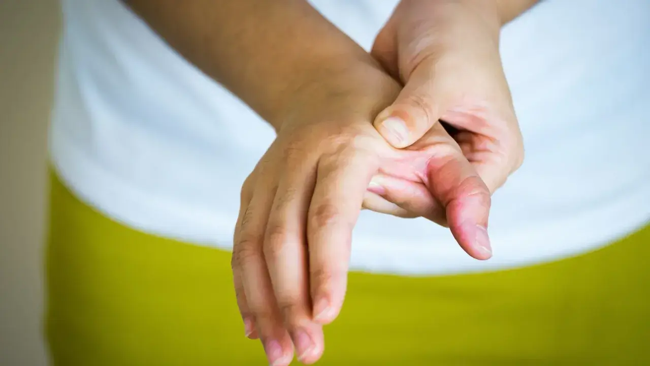Mano con dolor en el pulgar, buscando alivio y soluciones sobre como curar la rizartrosis del pulgar.