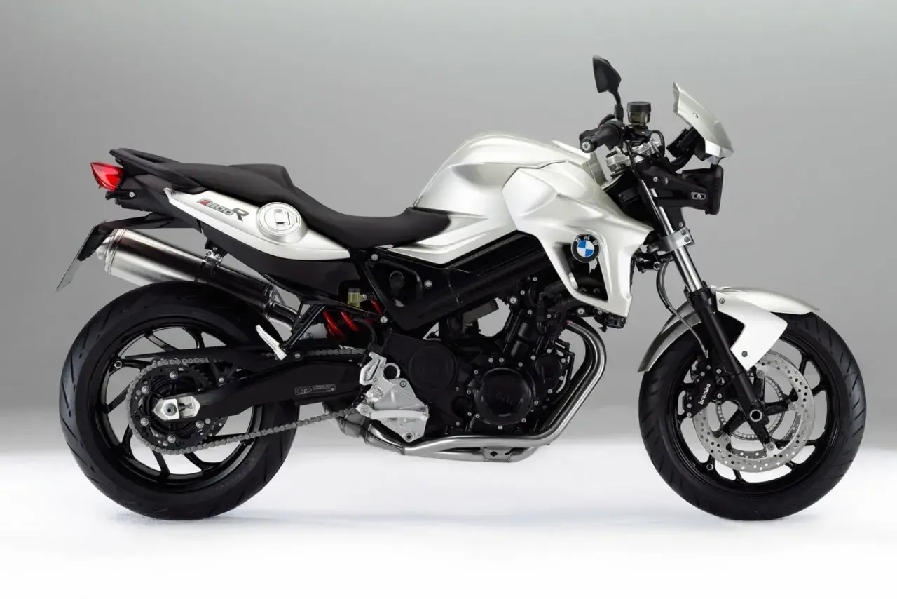 Srebrny motocykl BMW 800R z czarnym siedzeniem i detalami, prezentujący sportowy design i moc.