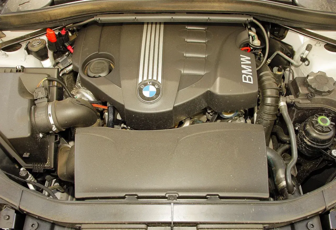 Silnik BMW X1 E84 z widocznym logo BMW i elementami układu dolotowego.