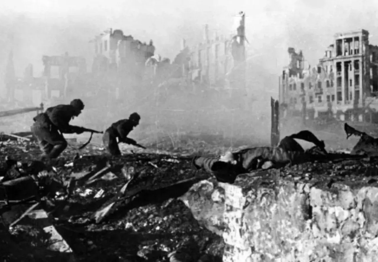 Soldater kämpar i ruiner. En fallen soldat ligger framför dem. Detta är en bild från slaget om Stalingrad, som idag heter Volgograd.