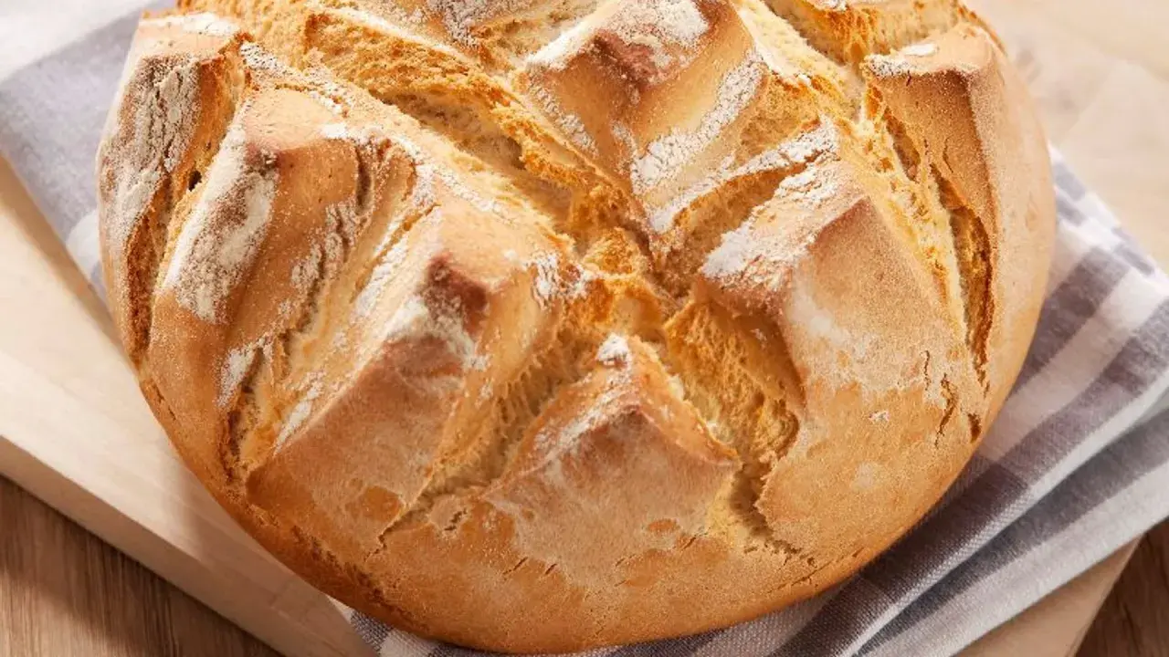 Pan rápido Thermomix, dorado y crujiente, con cortes en forma de rombos y espolvoreado de harina.