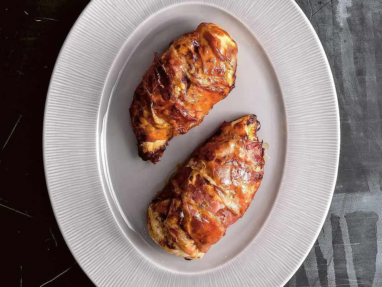 Två saftiga kycklingfiléer inslagna i bacon, perfekt tillagade i airfryer.