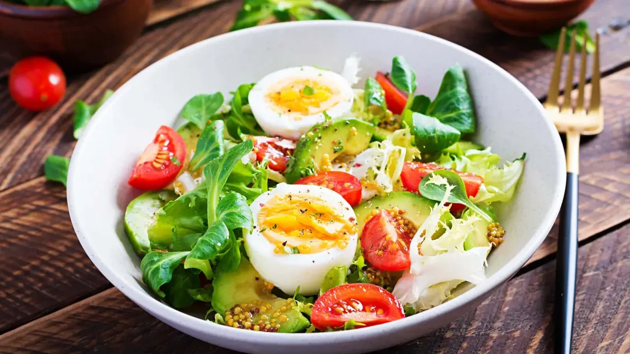 Frischer Salat mit Avocado, Tomaten und gekochten Eiern – perfekt für eine leichte Mahlzeit zum Abnehmen.