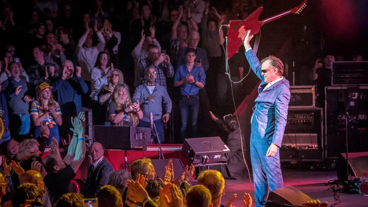 Joe Bonamassa tackar publiken med sin gitarr höjd. Ett kommande evenemang med Joe Bonamassa blir garanterat en succé!