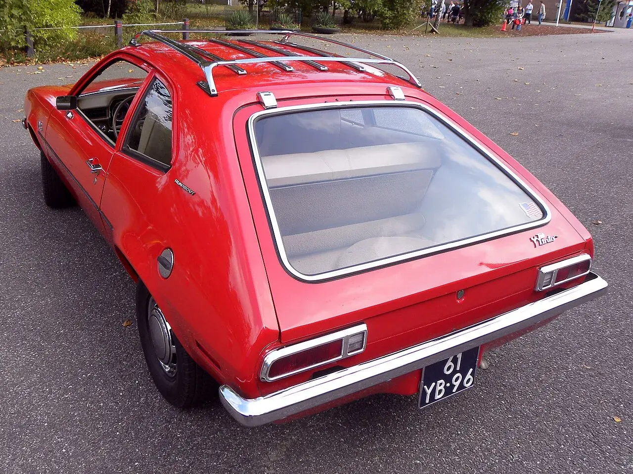 Czerwony Ford Pinto Runabout z bagażnikiem dachowym, gotowy na przygodę.