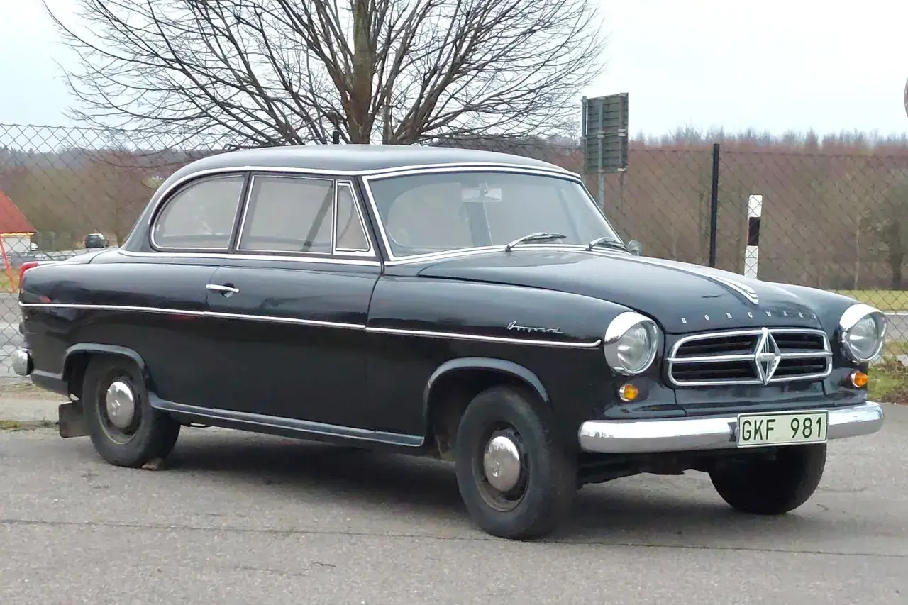 Svart Borgward Isabella, en klassisk bil med kromdetaljer, står parkerad utomhus.
