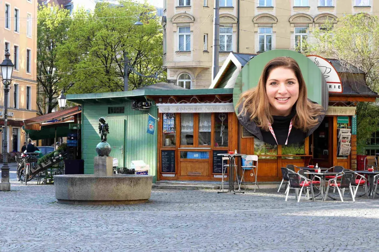 Lächelnde Frau vor einem Stehcafé in Haidhausen. Ein Brunnen und ein kleiner Junge als Statue sind im Vordergrund.