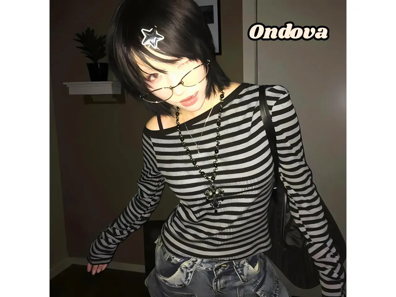 Dziewczyna w stylu y2k grunge, w bluzce w paski i okularach, z gwiazdką we włosach.