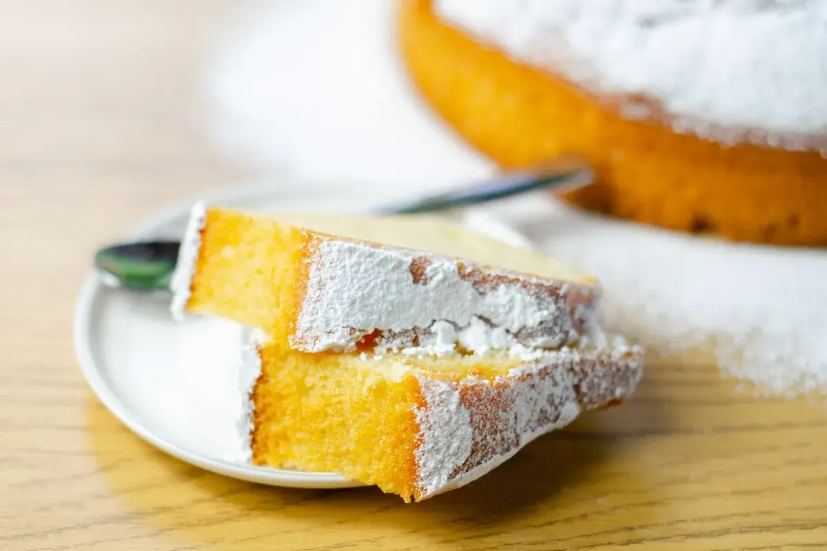 Due fette di torta soffice e dorata, spolverate di zucchero a velo, perfette per preparare torte golose facili.