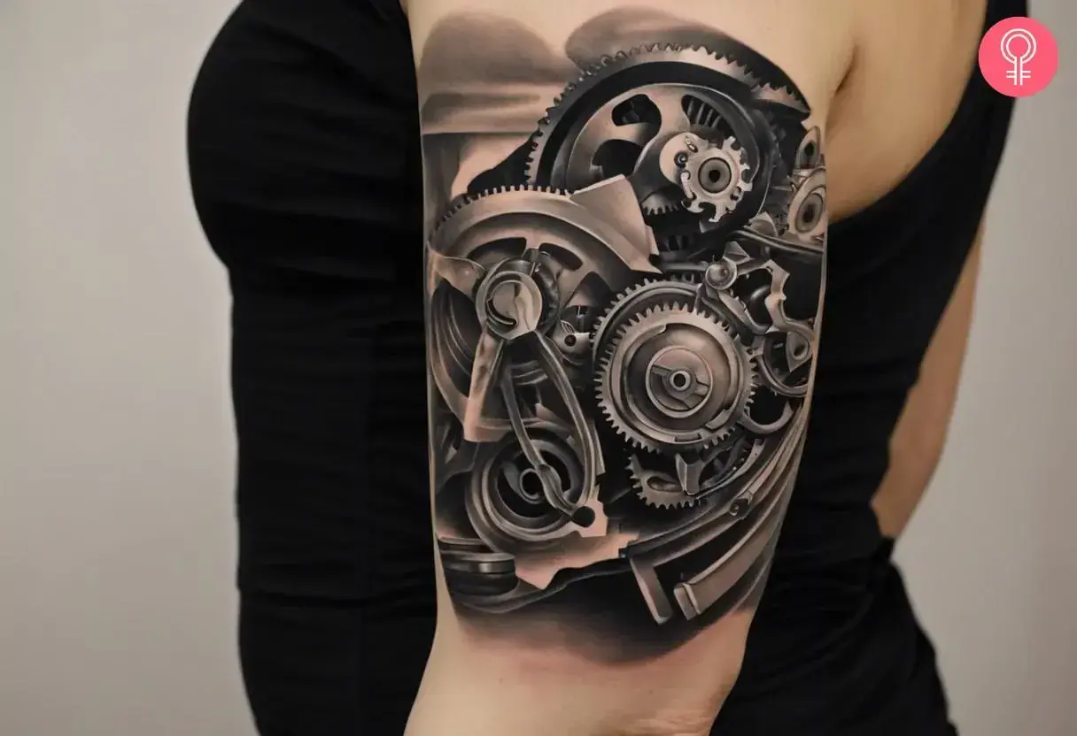 Tatuaż mechanicznej ręki z widocznymi zębatkami i elementami maszynowymi.