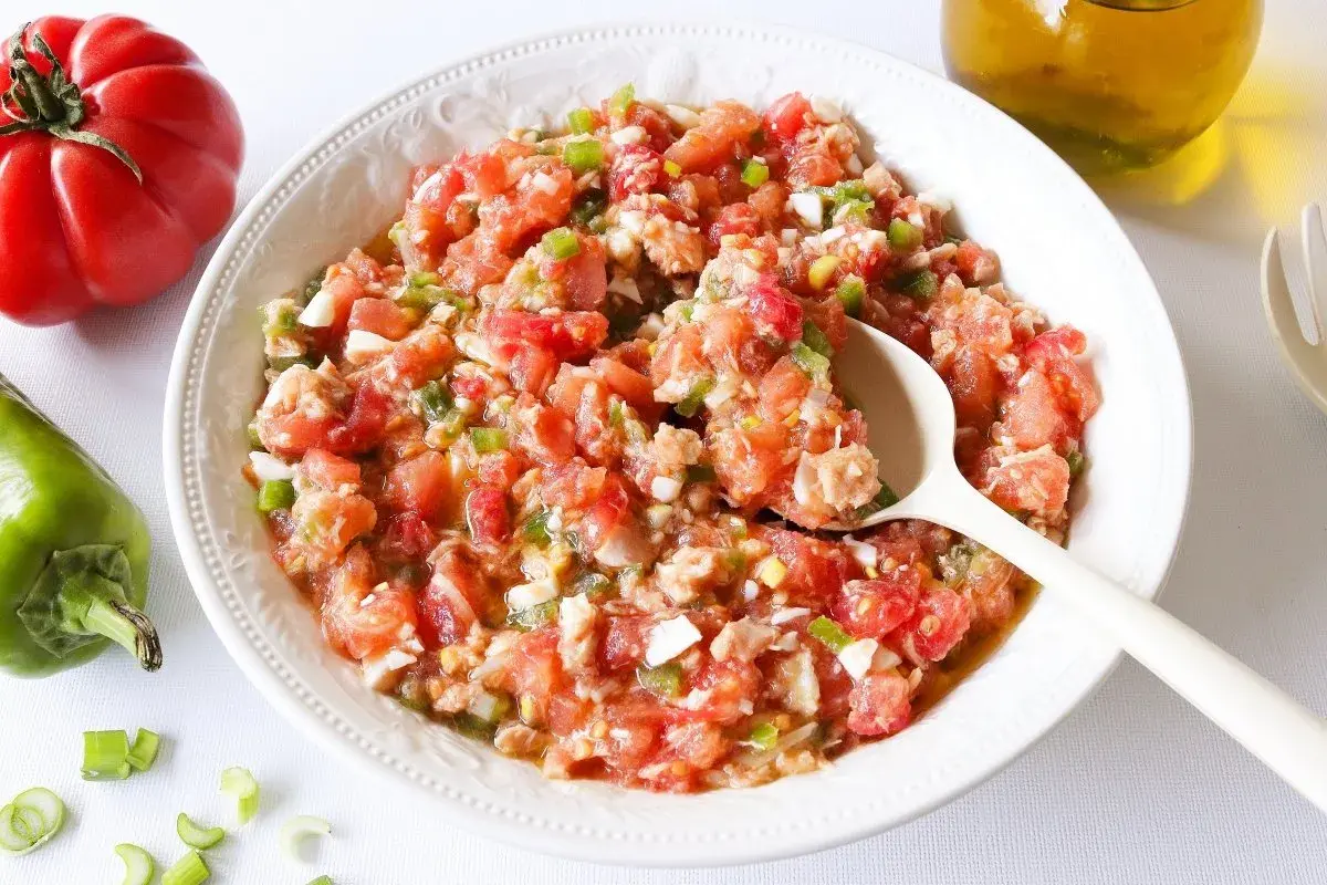 Un plato de pipirrana de Jaén, una ensalada fresca de tomate, pimiento y huevo, lista para disfrutar.